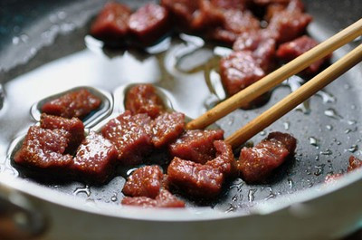 Phi thơm hành tây trên chảo nóng sau đó cho nước dùng xương bò vào cùng 1 lon bia và nấu sôi. Ảnh: designs-by-sara.com.