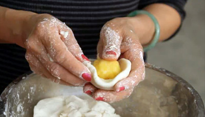 Làm nhân bánh: Ngâm đậu xanh trong nước ấm trước cho đậu nở hoàn toàn. Cho đậu xanh vào nồi hấp cho chín. Cho tất cả các nguyên liệu của nhân bánh vào một cái chảo, trộn đều. Bắt chảo lên bếp và đun với lửa nhỏ cho đến khi nhân đặc, quyện lại và có thể nắm lại là được. Viên đậu xanh lại thành những viên tròn rồi cho vào ngăn đông của tủ lạnh. Ảnh: Nau.vn.