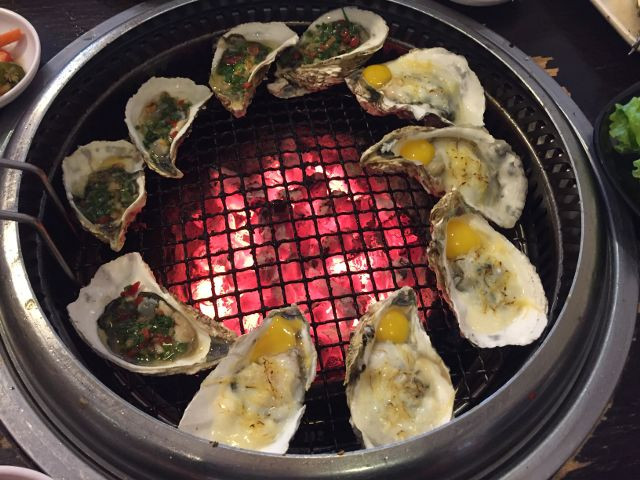 Xếp hàu đã tách lên vỉ nướng lại, dùng dao hoặc muỗng phết phô mai lên từng con hàu. 1 miếng phô mai chia ra phết cho khoảng 3 - 4 con. Ảnh: Lozi.vn.