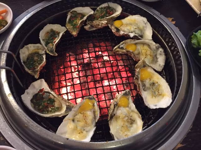 Xếp hàu đã tách lên vỉ nướng lại, dùng dao hoặc muỗng phết phô mai lên từng con hàu. 1 miếng phô mai chia ra phết cho khoảng 3 - 4 con. Ảnh: Lozi.vn.