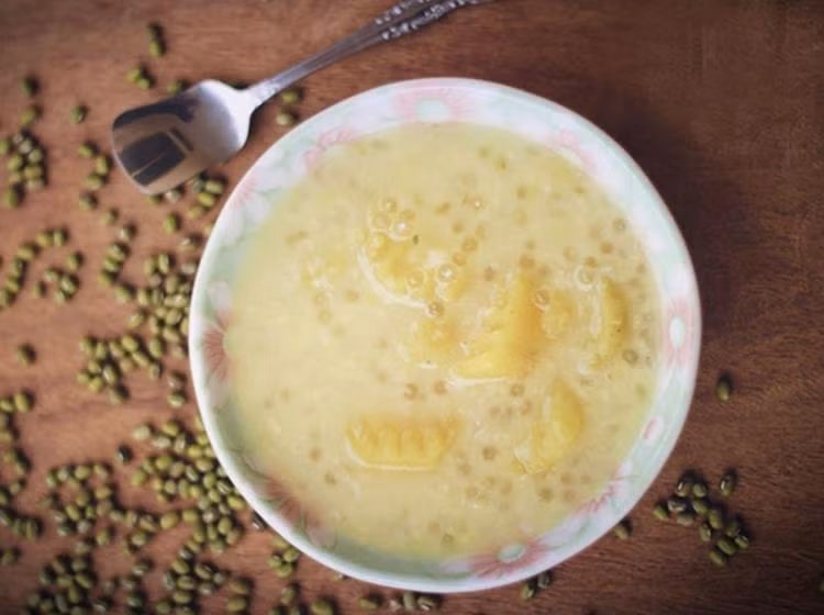 Nấu chè: Sau khi sôi, mẹ hãy vặn lửa nhỏ rồi đun thêm 15 phút nữa thì cho thêm khoai lang và số đường còn lại vào. Có thể thêm hoặc bớt đường tùy khẩu vị. Đến khi thấy khoai lang đã chín mềm thì đổ thêm nước cốt dừa vào đun cho chè hơi sôi là được. Ảnh: phunutoday.vn.