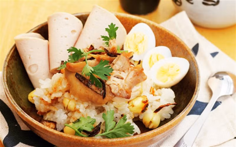 Vo sạch nếp. Cho nếp, hạt sen, 5g muối và 300ml nước dừa (xâm xấp mặt nếp) vào nồi và đem nấu chín. Bày xôi hạt sen ra ăn cùng thịt gà, chả lụa, trứng cút. Rắc lên mặt một ít hành phi và ngò cho thơm. Ảnh: Cooky.vn.