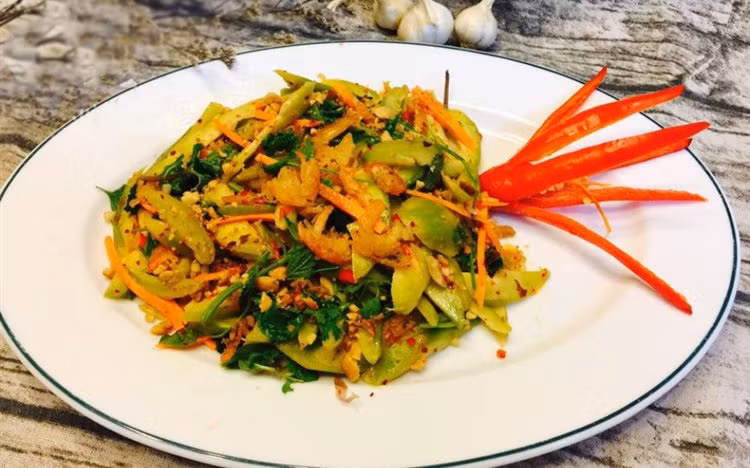 Cho cóc vào bát cóc cho tôm và đổ nước trộn lên, thêm rau thơm vào và trộn đều lên. Đổ nộm cóc tôm ra đĩa, rắc thêm lạc, là các bạn đã hoàn thành xong. Ảnh: cooky.vn.