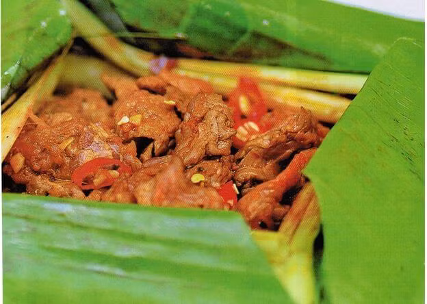 Kẹp vào vỉ nướng trở đều hai mặt trên lửa than. giữ lửa nhỏ ngọn để khi thịt chín, lá chỉ vừa nám, mở lá cuốn thịt ăn kèm ra sống bánh tráng. Ảnh: maythaithit.net.