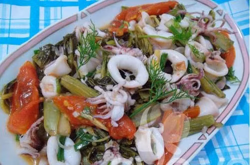 Dưa muối đem rửa sạch sau đó cho vào chảo đang xào mực, đảo đều lên. Xào lửa vừa phải, không nên xào lâu mực ra hết nước. Cho thì là và rau răm rồi nhấc xuống. Ảnh: Thegioiphunu.net.