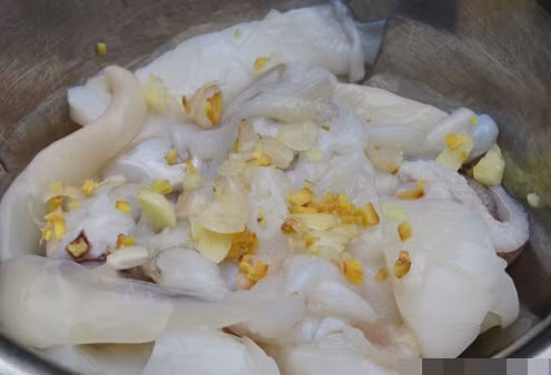 Làm sạch mực. Phi hành cho thơm, cho cà chua vào đảo đều rồi đổ mực vào, cho gừng và ớt vào cùng luôn. Xào mực, nêm gia vị. Ảnh: Ngoisao.vn.