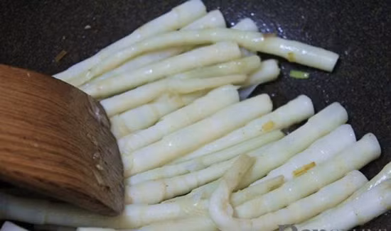 Cho hạt nêm vào. Khi măng chín đổ ra đĩa. Cho dầu ăn vào chảo cho tỏi băm vào phi thơm cho bê vào đảo tái rồi cho măng đã xào vào đảo đều. Ảnh: toinayangi.vn.