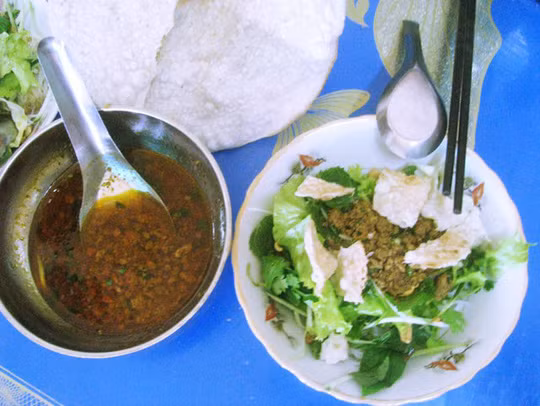 Phi hành tím cho thơm, cho cà chua vào xào, nêm vào 1 muỗng canh nước mắm, để nhỏ lửa cho cà chua chín nhừ, ra màu đỏ đẹp rồi đem đổ vào nồi nước dùng. 3 trái cà chua còn lại cắt làm 4, cho vào nồi nước dùng luôn. Nêm gia vị. Ảnh: nld.com.