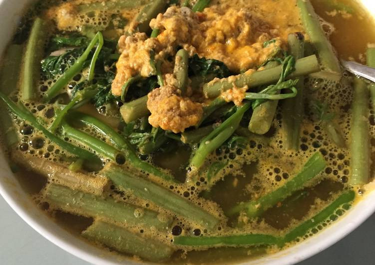 Cho rạm lên bếp đun to lửa. Cho tất cả gia vị vào khi canh sôi ta vặn nhỏ lửa. Thấy gạch nổi lên vớt gạch để riêng. Sau đó cho khoai sọ vào nấu khi thấy khoai chín bở thì cho tiếp rau rút vào. Thấy sôi cho gạch vào để lên trên là hoàn thành. Ảnh: cookpad.com.