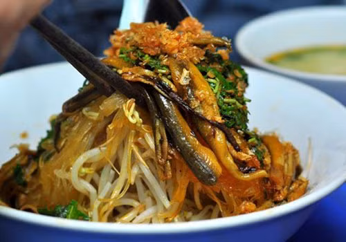 Lươn ướp với ngũ vị hương, tiêu, đường, hạt nêm. Rán thật chín rồi cắt nhỏ để trộn cùng. Làm sốt trộn gồm nước tương, quất lấy nước cốt, đường. Khuấy lên rồi trộn cùng giá, lươn, hành phi, lạc rang, mỡ hành, miến, rau răm là hoàn thiện. Ảnh: Youvivu.com.