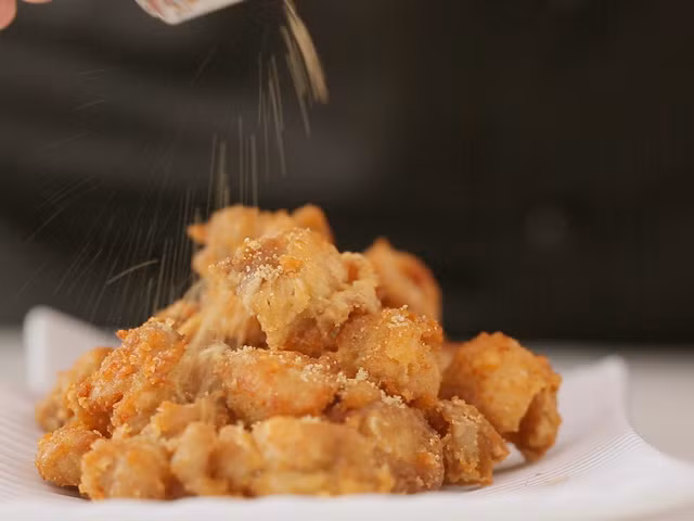 Cho nhiều dầu vào chảo, đun nóng dầu rồi gắp từng miếng thịt cho vào chiên, khi thịt chín vàng giòn thì vớt ra đĩa có lót sẵn giấy thấm dầu. Tiếp đó, cho rau húng quế vào chiên 1-2 phút thì vớt rau húng ra đĩa cho thấm bớt dầu. Ảnh: eva.vn.