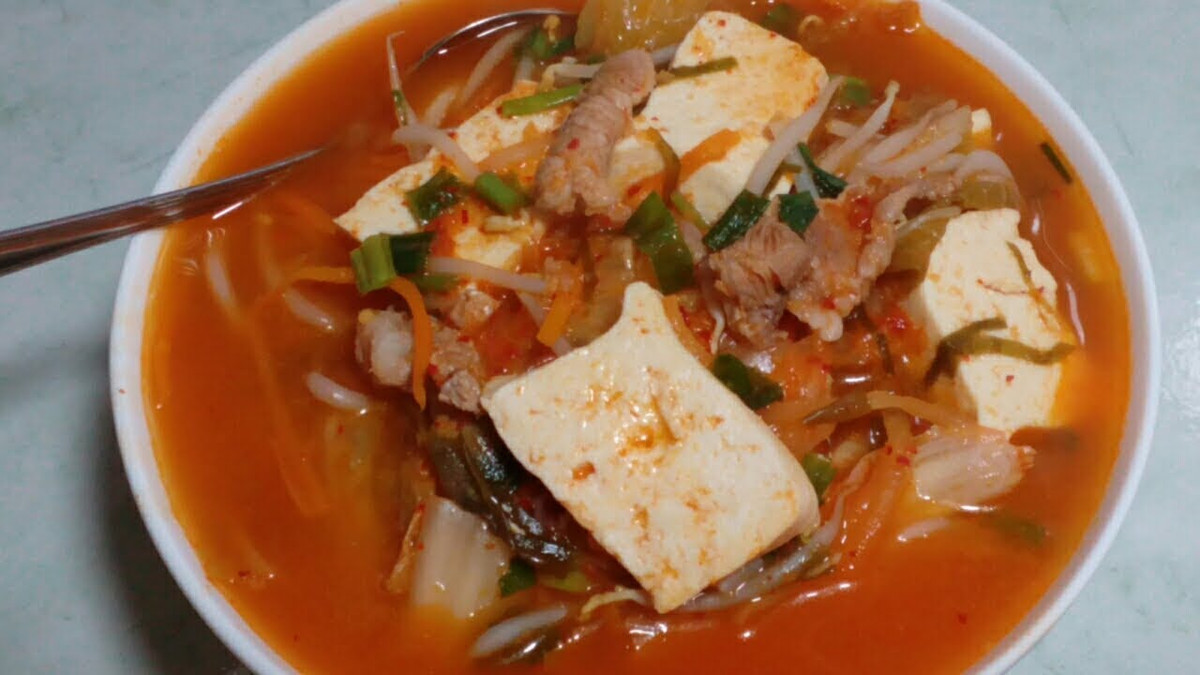 Đổ dầu ăn vào nồi, cho cà chua vào xào qua, đổ nước vào đun sôi. Thả đậu hũ, thịt vào sau đó là giá đỗ, đun lửa to, cho nồi canh sôi trở lại. Cuối cùng cho hành thái khúc vào rồi tắt bếp. Ảnh: youtube.com.