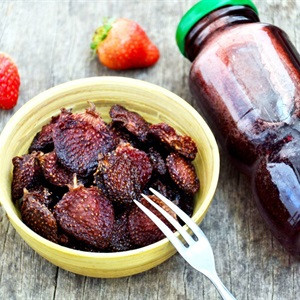 Cho mứt ra khay, dàn đều cho nguội bớt.Làm nóng lò nướng ở nhiệt độ cao nhất trong 10 phút, sau đó cho dâu tây vào. Sấy ở 100 độ C trong 2 tiếng để dâu được khô hẳn. Ảnh: Cooky.vn.