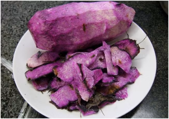 3. Chè khoai tía. Nguyên liệu: Khoai tía, đường trắng, vani, muối hột. Khoai tía gọt sạch vỏ, rửa sạch, cắt thành miếng nhỏ. Nấu chín với lượng nước vừa phải. Để nhỏ lửa khoảng 15 phút để khoai chín từ từ. Ảnh: Vntrip.vn.