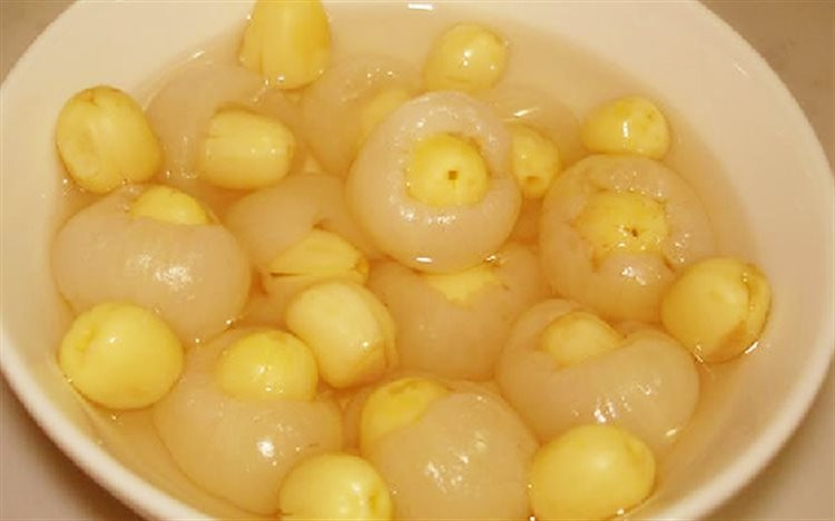 Lọc lại nước luộc hạt sen, cho đủ khoảng 1 lít là được. Cho thêm đường vào nồi hạt sen, đặt lên bếp đun sôi sao cho đường tan hoàn toàn. Tiếp đến bạn cho phần nhãn đã bọc hạt sen vào trong nồi và đun trong khoảng 10 phút cho thật ngấm đường rồi tắt bếp. Ảnh: Cooky.vn.