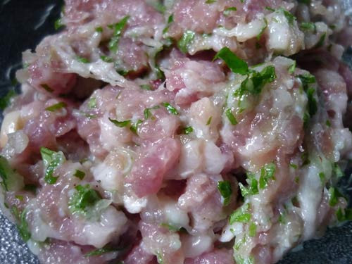 Nấm hương, mộc nhĩ ngâm nở, rửa sạch rồi băm nhỏ. Trộn thịt với nấm hương, mộc nhĩ, hành khô băm nhỏ và gia vị, hạt tiêu cùng chút dầu ăn. Trải lươn ra thớt, cho thịt vào cuộn, cứ cuộn được 1 vòng mà lươn còn dài, dùng dao cắt đi để nửa sau lại cuộn thêm được một miếng nữa. Ảnh: vietbao.vn.