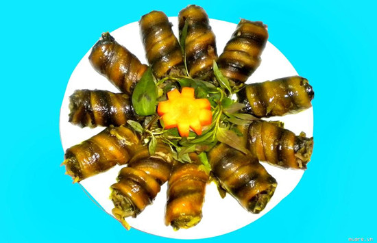 Sau đó dùng hành lá trụng sơ qua nước nóng cột chặt miếng lươn lại. Cho dầu ăn vào chảo rán sơ miếng lươn cuộn rồi vớt ra đĩa để ráo dầu. Phi thơm hành khô. Cho cà chua vào xào chín mềm rồi thêm chút nước vào đun sôi. Thả lươn vào om cho đến khi nước cạn sệt lại. Cuối cùng thêm rau răm vào và tắt bếp. Ảnh: haiyen20.vn.