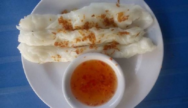 Để một thìa canh bột vào chảo rồi lắc đều quanh chảo, sau đó đậy vung trong 15 giây để bột chín. Tráng bột càng mỏng thì bánh càng ngon. Cho nhân vào giữa bánh rồi cuốn lại. Pha nước chấm bạn pha theo công thức: 1 thìa giấm gạo, 1 thìa nước mắm, 1 thìa đường, 6-7 thìa nước. Ảnh: tintucvietnam.vn.