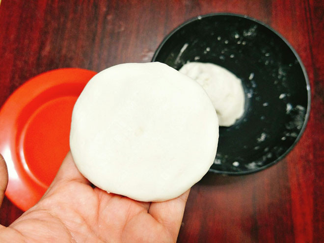 Cho bột nếp và bột tẻ, muối vào tô rồi trộn đều. Đổ sữa vào hỗn hợp bột rồi trộn thành khối mịn, khi bột không dính tay là được. Chia bột thành 12 hoặc 16 phần bằng nhau, vo tròn và sau đó ấn cho viên bột dẹt ra và đặt bột lên lá chuối. Ảnh: danviet.vn.