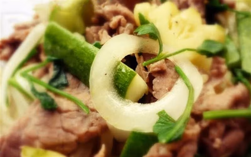 Dưa leo chẻ đôi cắt chéo, hành tây chẻ đôi cắt ra từ miếng. Đợi dầu nóng cho hành tây đảo cho thơm. Cho thịt bò đã ướp vào xào hơi tái. Cho tiếp hành tây vào đảo đến khi hành gần chín. Nêm lại cho vừa ăn rồi cho cà chua và dưa leo vào rồi tắt bếp. Ảnh: Cooky.vn.