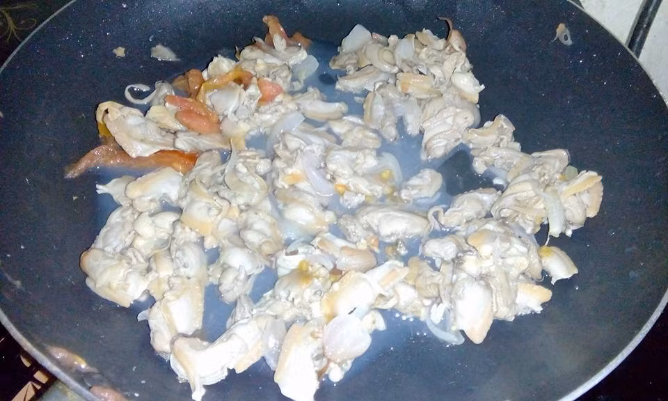 Tiếp tục thêm dầu vào chảo vừa xào ngao, cho chỗ hành tỏi còn lại vào phi thơm và đổ bí đỏ, hành tây vào xào đều tay. Nêm vào hành tây, bí đỏ chút gia vị. Ảnh: BepGiaDinh.com.