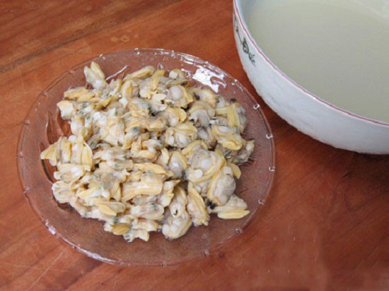 Luộc ngao lên rồi gạn nước luộc ngao để riêng sang một bên cho lắng cặn. Tách bỏ vỏ ngao, nặn bỏ phần đen ở ruột rồi bằm nhuyễn. Bắc nồi, cho ít dầu ăn vào, phi đầu hành cho thơm rồi trút ngao vào đảo đều. Ảnh: toinayangi.vn.