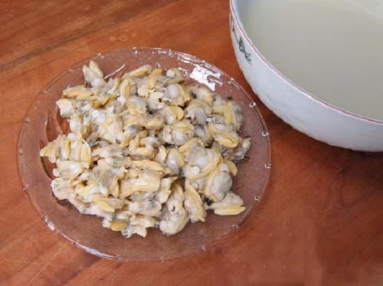 Luộc ngao lên rồi gạn nước luộc ngao để riêng sang một bên cho lắng cặn. Tách bỏ vỏ ngao, nặn bỏ phần đen ở ruột rồi bằm nhuyễn. Bắc nồi, cho ít dầu ăn vào, phi đầu hành cho thơm rồi trút ngao vào đảo đều. Ảnh: toinayangi.vn.