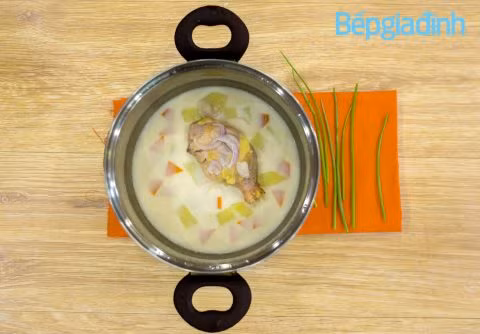 Hầm đùi gà trên lửa nhỏ khoảng 15 phút, cho sữa tươi cùng muối, đường vào, sau đó nấu sôi bớt lửa rồi hớt bọt thật kỹ, cho hành tây cắt khoanh vào nấu 5 phút, nhấc xuống. Múc đùi gà nấu sữa tươi vào thố, dọn dùng nóng với bánh mì. Ảnh: BepGiaDinh.com.