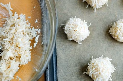 4. Bánh dừa. Nguyên liệu: Dừa sấy, bột mì, sữa bột, sữa, lòng đỏ trứng, đường, bơ. Để bơ ở nhiệt độ phòng cho mềm, sau đó cho đường vào đánh đều. Rồi từ từ thêm lòng đỏ trứng vào, vừa cho vừa đánh đều. Sau đó đổ phần sữa đã chuẩn bị sẵn vào, trộn đều. Ảnh: blog.beemart.vn.