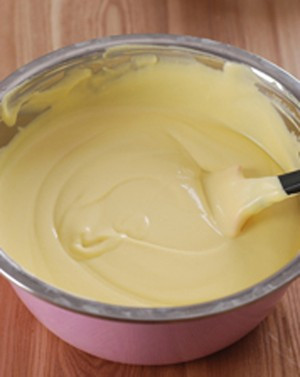 Bắc nồi, bật bếp lửa nhỏ vừa, cho hỗn hợp xoài vào đun trong 2 đến 3 giờ. Đổ hỗn hợp xoài đã nấu đủ thời gian lên, láng thật mỏng và đều trên khay. Rắc thêm vừng nếu muốn. Ảnh: zing.vn.