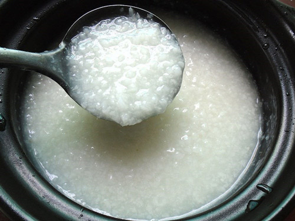 Đậu Hà Lan sơ chế, cho vào nồi, đổ ngập nước, nấu chín mềm. Sau khi đậu chín, nghiền nát đậu bằng tay. Hành đập dập, phi thơm, trút thịt heo đã băm sẵn vào xào sơ qua, nêm gia vị vừa đủ. Thịt lợn chín tới, cho vào cháo trắng đảo đều.