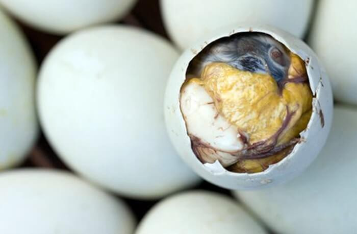 3. Cháo trứng vịt lộn. Nguyên liệu: Gạo, trứng vịt lộn, nấm rơm, rau đắng, hành lá, ngò rí, rau răm, hành tím, muối, hạt nêm, nước mắm, đường. Gạo rang lên cho hơi vàng. Sau đó rửa sạch, bỏ với nồi cùng 1 lít nước, lửa liu riu. Ảnh: Giadungbep.com.