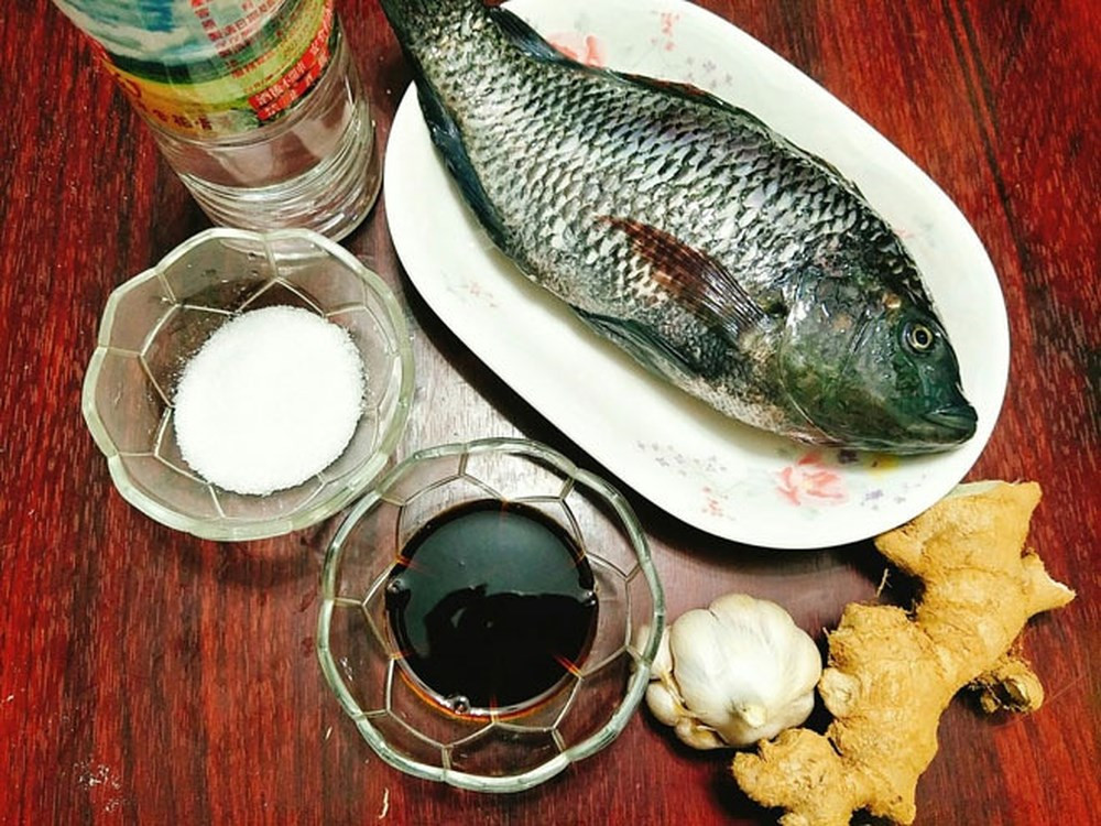 4. Cá rô phi sốt. Nguyên liệu: Cá rô phi, cà chua, hành, răm, thì là, dầu ăn, bột canh, nước mắm. Cá làm sạch cắt khúc nếu to quá, khía, rán giòn tùy theo khẩu vị.