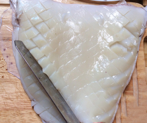 Mực làm sạch, để ráo, thái thành từng miếng vừa, khía vẩy rồng. Ướp mực với tỏi, hạt nêm, nước mắm, tiêu bột, dầu ăn trong 20 phút. Phi thơm 3 thìa dầu ăn với phần hành tỏi băm nhuyễn còn lại và ½ thìa ớt bột, cho mực vào xào nhanh tay với lửa lớn trong 5 phút, khi thấy mực vừa chín tới bạn trút ra đĩa. Ảnh: dacsanthonque.com.