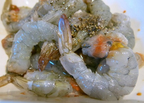 Trong lúc đó, cho me vào bát nước sôi, dầm cho tan, bỏ hột, lấy phần nước me. Tỏi băm nhỏ. Hành lá, rau mùi tàu thái nhỏ. Đặt chảo lên bếp, cho dầu ăn vào đun nóng, cho 1 thìa cà phê bột điều. Ảnh: toinayangi.vn.