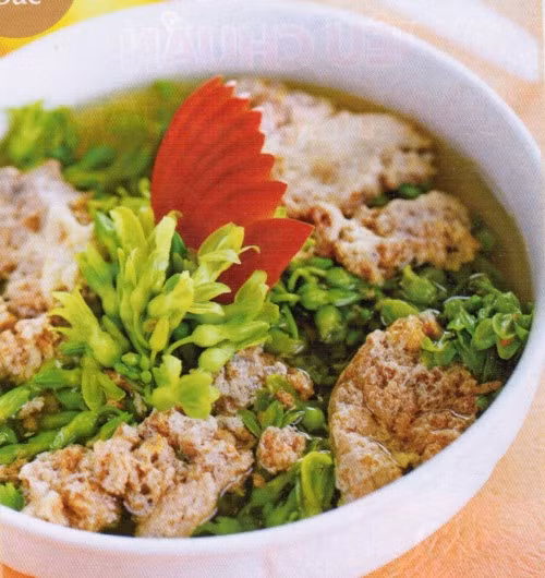 Chờ canh sôi thì cho hoa thiên lý vào, vặn lửa to để canh sôi lại. Cho chỗ gạch cua đã làm sạch vào nồi canh đang sôi để gạch cua tan ra, tạo thành một màu vàng trên mặt nồi canh thì tắt bếp. Nêm bột gia vị, hạt nêm sao cho vừa ăn. Ảnh: doisongphapluat.com.
