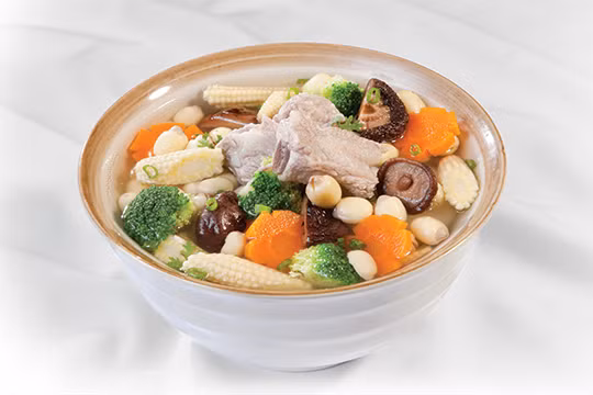 Cho sườn vào nấu 20 phút. Hớt bỏ bọt nếu có. Cho hạt sen, nấm hương, ngô ngọt và nêm thêm 1 thìa mắm, gia vị cho vừa miệng, nấu thêm 10 phút. Cho cà rốt, súp lơ xanh (bắp ngô non) nấu thêm 2 phút cho hành ngò tắt bếp. Múc ra tô, trang trí, ăn nóng. Ảnh: monngonmoingay.com.