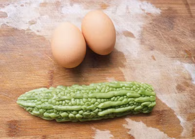 3. Trứng rán tôm mướp đắng. Nguyên liệu: Mướp đắng, tôm khô, trứng, đường, dầu mè, hạt tiêu, muối. Thái mướp đắng thành những lát thật mỏng. Chần qua nước sôi với một chút muối, sau đó nhúng ngay vào nước lạnh. Ảnh: aFamily.vn.