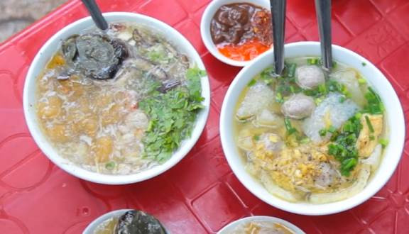 Thịt cua trộn với hành tây, 1/3 thìa cà phê bột tiêu và ít dầu, đảo đều. Cho bóng cá và thịt cua vào nồi nước dùng, nấu chín kỹ. Hòa bột năng với ít nước lạnh, khuấy cho tan, cho bột vào canh, khuấy đều, đun sôi. Trứng đánh tan, rưới vào súp, khuấy đều, múc ra bát, rắc rau mùi thái nhỏ, hạt tiêu. Ăn ngay khi còn nóng. Ảnh: Foody.vn.