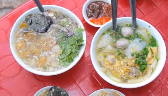 Thịt cua trộn với hành tây, 1/3 thìa cà phê bột tiêu và ít dầu, đảo đều. Cho bóng cá và thịt cua vào nồi nước dùng, nấu chín kỹ. Hòa bột năng với ít nước lạnh, khuấy cho tan, cho bột vào canh, khuấy đều, đun sôi. Trứng đánh tan, rưới vào súp, khuấy đều, múc ra bát, rắc rau mùi thái nhỏ, hạt tiêu. Ăn ngay khi còn nóng. Ảnh: Foody.vn.