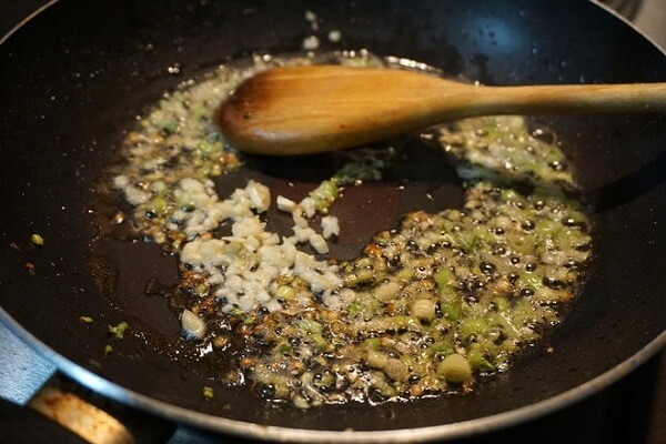 Bắc chảo lên bếp, dầu nóng cho hành tăm vào phi thơm. Hành thơm vàng, cho bao tử cá vào xào. Khi bao tử cá săn lại thì nêm chút gia vị sau đó cho bao tử cá ra đĩa để riêng. Thêm thìa dầu ăn, cho tiếp dưa cải chua vào xào, nêm chút gia vị. Dưa chín, ngấm gia vị thì cho bong bóng cá trở lại chảo, đảo đều, nêm nếm cho vừa miệng. Ảnh: 24h.com.vn.