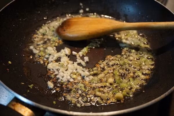 Bắc chảo lên bếp, dầu nóng cho hành tăm vào phi thơm. Hành thơm vàng, cho bao tử cá vào xào. Khi bao tử cá săn lại thì nêm chút gia vị sau đó cho bao tử cá ra đĩa để riêng. Thêm thìa dầu ăn, cho tiếp dưa cải chua vào xào, nêm chút gia vị. Dưa chín, ngấm gia vị thì cho bong bóng cá trở lại chảo, đảo đều, nêm nếm cho vừa miệng. Ảnh: 24h.com.vn.