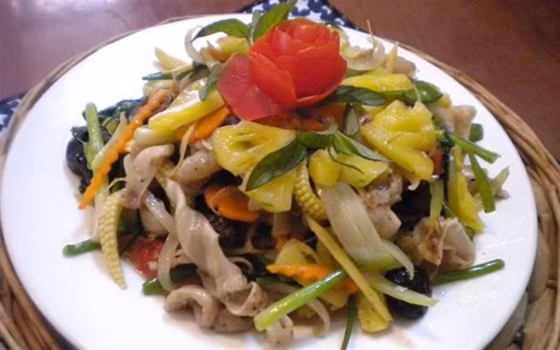 Tiếp tục cho chảo dầu nóng già, phi thêm hành tỏi băm nhỏ lần lượt cho nấm hương, cà rốt, ngô non, đậu hà lan, cần tây, hành hoa cho sau cùng nêm nếm gia vị vừa ăn, đảo nhanh tay cho các nguyên liệu chín đều. Sau cùng trút phần bong bóng cá đã xào từ trước vào chảo rau củ đảo đều trên bếp khoảng chừng 2 phút rồi tắt bếp. Trút ra đĩa và rắc hạt tiêu lên trên. Ảnh: Cooky.vn.