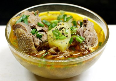 Đổ nước xâm xấp vịt, thêm rượu trắng, đường, muối, nước mắm, tiêu, mì chính đun nhỏ lửa khi thịt vịt chín mềm. Hòa bột đao vào bát nhỏ rồi đổ vào thịt vịt, đảo đều tay cho nước sốt sánh là được. Cho thịt vịt om dứa ra bát tô, rưới nước sốt lên trên, rắc thêm tiêu và trang trí bằng rau mùi. Ảnh: PizzaExpress.com.vn.