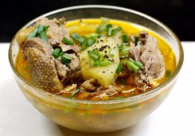 Đổ nước xâm xấp vịt, thêm rượu trắng, đường, muối, nước mắm, tiêu, mì chính đun nhỏ lửa khi thịt vịt chín mềm. Hòa bột đao vào bát nhỏ rồi đổ vào thịt vịt, đảo đều tay cho nước sốt sánh là được. Cho thịt vịt om dứa ra bát tô, rưới nước sốt lên trên, rắc thêm tiêu và trang trí bằng rau mùi. Ảnh: PizzaExpress.com.vn.