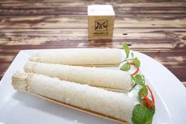 Ống nứa có khói mùi thơm thì nghĩa là cơm đã chín nhé. Để các ống nứa nguội bớt, dùng dao chẻ bỏ lớp ngoài của ống nứa chỉ để một lớp lạt giang mỏng bên trong mà thôi. Khi ăn các bạn chặt nhỏ ống nứa ra, tách lấy cơm ở bên trong ăn kèm với muối vừng, thịt lợn hay thịt gà. Ảnh: monngonanlien.com.