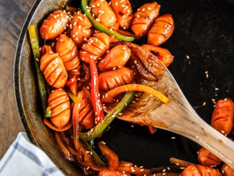 Cho xúc xích lên chảo rồi đổ nước sốt lên, đảo đều tầm 1 phút cho ngấm hết gia vị là được. Ảnh: Nauzi.com.