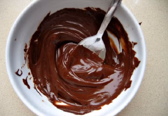 4. Bắp rang bơ vị sô cô la. Nguyên liệu: Hạt ngô, đường, bơ, chocolate, vani. Cho ½ số bơ vào bát dùng cho lò vi sóng rồi đặt vào lò vi sóng quay ở chế độ rã đông để bơ tan. Ảnh: homnayangi.vn.