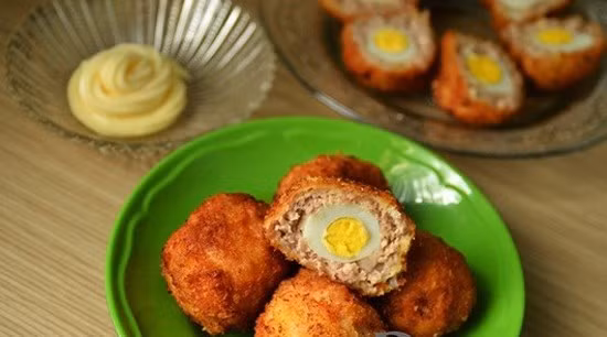 Lăn viên thịt đó qua lớp bột mì (hoặc bột chiên giòn), rồi lăn qua bát trứng gà, tiếp đến là lăn qua bột chiên xù. Sau đó đem chiên trong chảo dầu, chín vàng là được. Khi ăn, có thể chấm với sốt mayonnaise, tương ớt. Ảnh: menaunuong.WordPress.com.