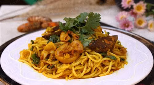 Trút phần nghệ đã giã nát vào chảo. Tiếp theo cho hết phần hành tây, rau răm cùng lá hẹ. Nêm nếm cho vừa miệng, hơi đậm một chút để sau khi cho bún vào sẽ vừa ăn. Cuối cùng cho bún tươi vào để lửa nhỏ và trộn đều tay. Lấy bún xào nghệ ra đĩa, ăn kèm với ớt trái cắt lát. Ảnh: baokhanhhoa.vn.